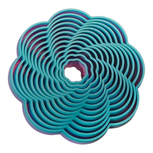 Top Down view of a 3D printed flower-shaped fidget toy in rainbow filament with layered, petal-like rings that create flowing, wave-like motion for stress and anxiety relief.