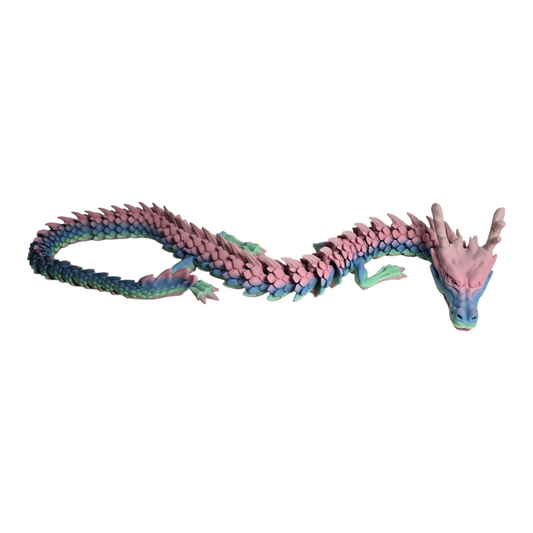 rainbow filament articulated 3D printed dragon curled on desk; large flexi 3D printed dragon nearly 1 meter display